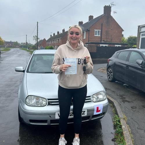 Person holding driving test pass certificate.