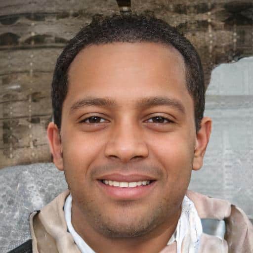 Smiling person standing by stone wall