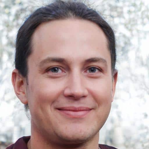Smiling person with a background of trees.