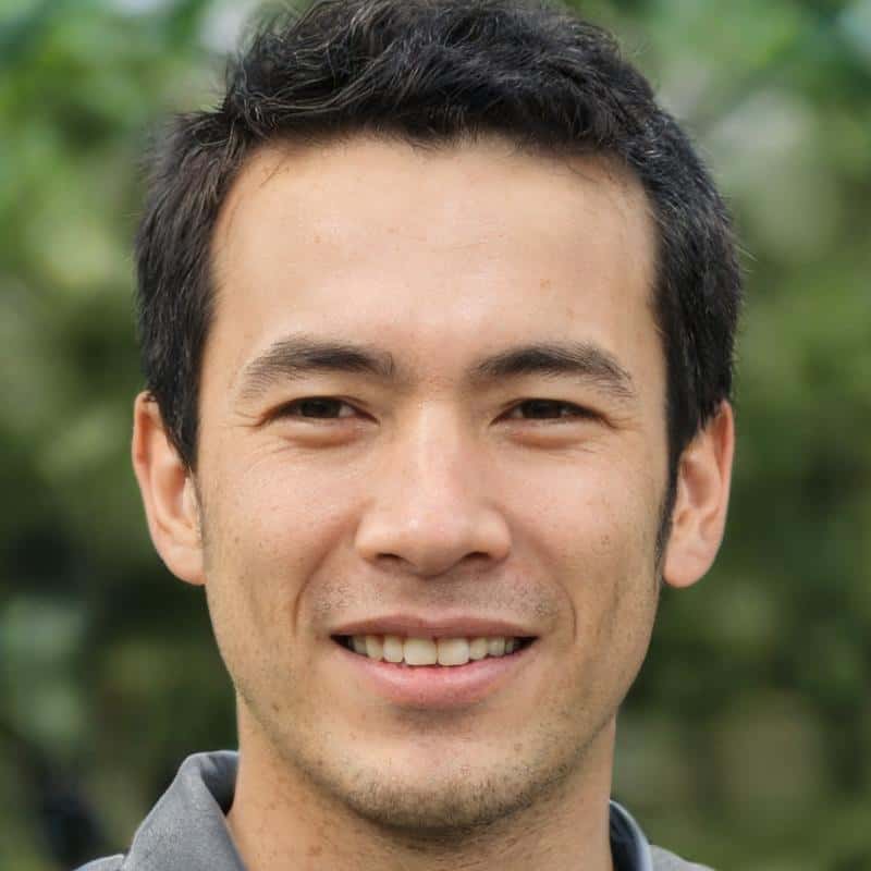 Smiling man outdoors with green background