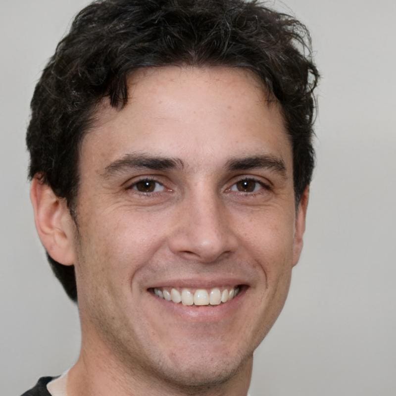Smiling man with dark hair and white background