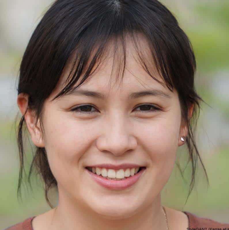 Smiling woman outdoors with brown hair.