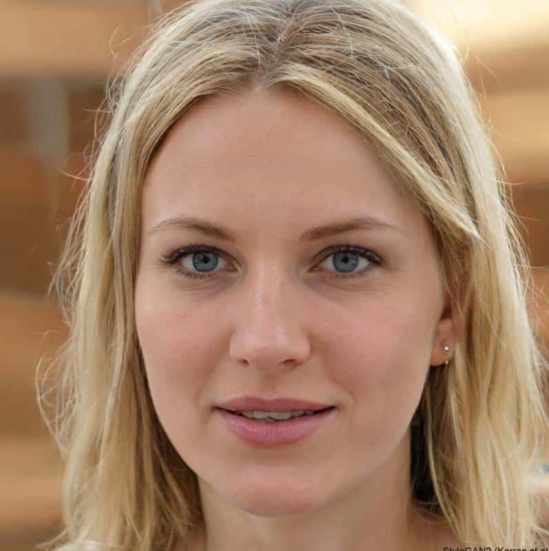 Young blond woman with blue eyes smiling slightly.